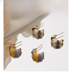 Detail view of colorful enamel bamboo hoop earrings with gold plating on a mirror background