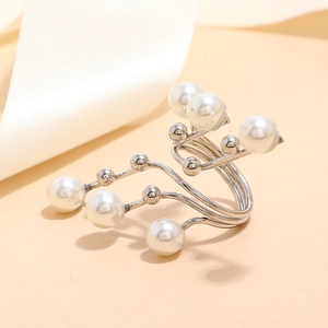 Detailed view of layered silver-tone ring with diverse white faux pearls on ribbon