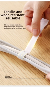 Action shot of durable white nylon cable tie wrapping wires over wooden desk