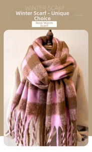 Detailed view of pink and brown plaid scarf with fringe tassels on beige coat
