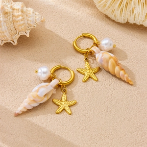 Seaside charm hoop earrings with starfish, pearl and conch pendant on beach sand background