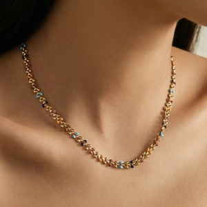 Golden leaf necklace with colorful enamel inlays on woman neck in bohemian style
