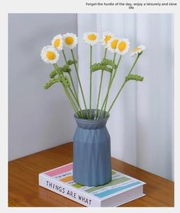 Handcrafted crochet daisy bouquet with 7 white yarn flowers in a blue geometric vase