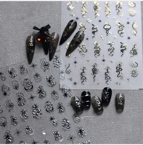 Detail of metallic dragon and sun nail stickers with gold and silver celestial patterns