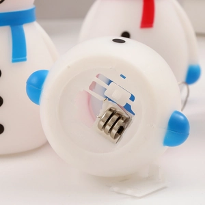 Vue détaillée de la base de la lampe bonhomme de neige avec trois piles bouton AG13