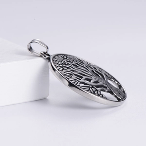 Macro side view of silver Tree of Life pendant with intricate hollow engraving details