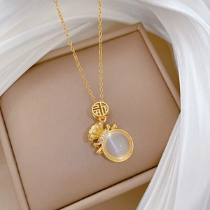 Détail du collier pendentif sac porte-bonheur doré avec opale et zircons brillants