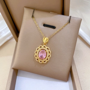 Vue détaillée du collier doré en forme d'œuf avec pierre rose et halo de zircons
