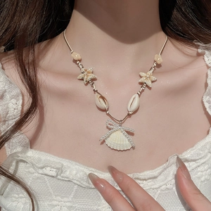 Detailaufnahme der Seestern- und Muschelkette mit Perlenbogen auf weißer Spitze