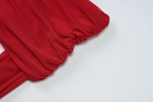 Detail of red mesh fabric with pleated design and high-quality stitching on the dress
