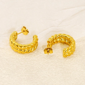 Gros plan sur les boucles d'oreilles torsadées en acier inoxydable plaqué or 18 carats