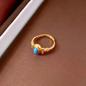 Vintage gold textured ring with oval blue stone and white zircon accents for women