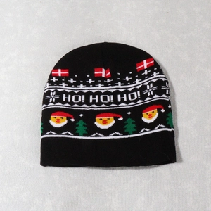 Detail of knitted Christmas beanie featuring Ho Ho Ho text and Santa Claus patterns