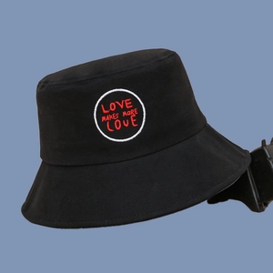 Detail of black cotton bucket hat featuring embroidered LOVE MAKES MORE LOVE round patch