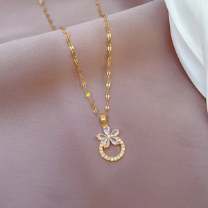 Detail of flower pendant necklace with micro-inlaid zircons on soft pink silk fabric