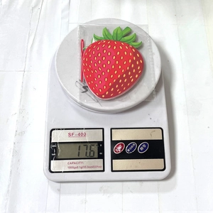 Detailed view of a strawberry shaped silicone tag showing vibrant red texture and green leaf