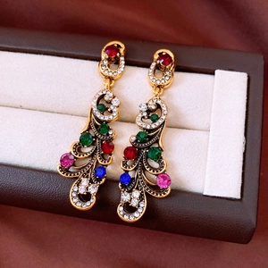 Detail of vintage geometric earrings with colorful rhinestones in a brown jewelry box