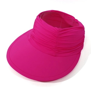 Detail of hot pink sun visor featuring wide brim and pleated elastic headband design