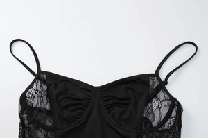 Dettaglio del patchwork in pizzo nero e del tessuto a pieghe sull'abito aderente