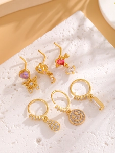 Detailed view of 18k gold-plated nose studs set with sparkling zircon in various shapes