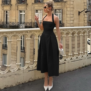 Dettaglio dell'elegante abito midi nero a sottoveste con gonna a pieghe e tessuto operato