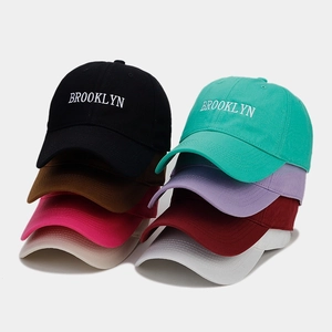 Detailed close-up of embroidered Brooklyn text on multi-colored cotton baseball caps