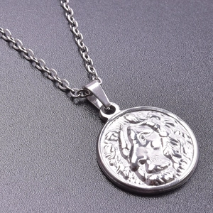 Detailed close-up of a silver stainless steel lion relief pendant and metallic chain
