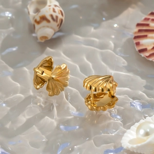 Gold shell-shaped stainless steel earrings with striped texture on water background