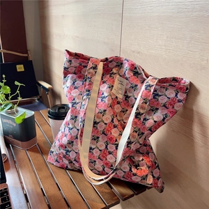 Close-up of floral cotton tote bag featuring vintage rose pattern and fabric brand label