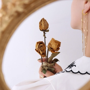 Elegant gold heart tassel earrings featuring long metal chain fringe on a female model