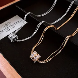 Gelaagde gouden en zilveren kettingen met zirkoon kubussen op zwart sieradendisplay