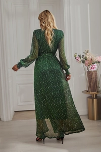 Back view of a long green midi dress with white polka dots and elegant flowing skirt