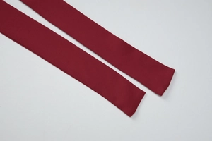 Detailed macro shot of the deep red woven fabric fringe strap with fine texture