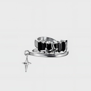 Detailed macro view of silver star ring with black stones and cross charms