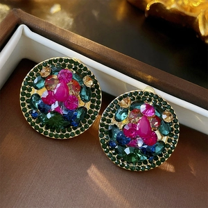 Macro view of geometric round ear clips with colorful rhinestones in a jewelry box