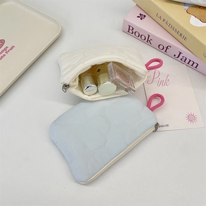 Close-up of quilted cloud texture coin purses in blue and beige with pink lanyards