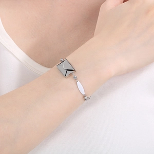 Close-up of a silver envelope pendant bracelet with zircons worn on a wrist