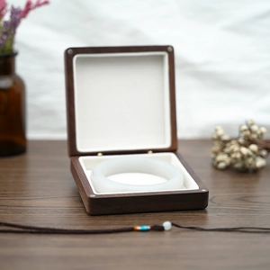Exquisite white jade bangle displayed in a premium wooden jewelry box with white cushion