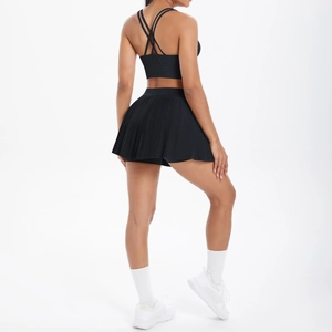 Détail du dos croisé de la brassière de sport noire et de la jupe de tennis plissée assortie