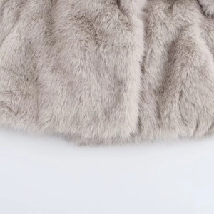 Gros plan sur la texture en fausse fourrure grise d'un manteau court à revers