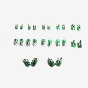 Short square press-on nails with green gradient, black leaf patterns and gold glitter