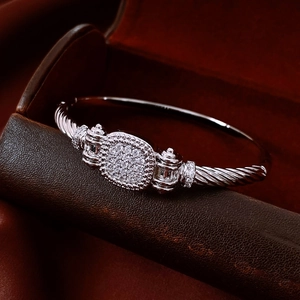 Nahaufnahme von silbernem gedrehtem Kabelarmband mit Pavé-Diamanten auf Leder
