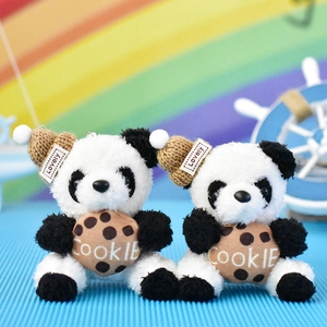 Detailopname van twee schattige panda pluche sleutelhangers met koekjes en gebreide mutsen
