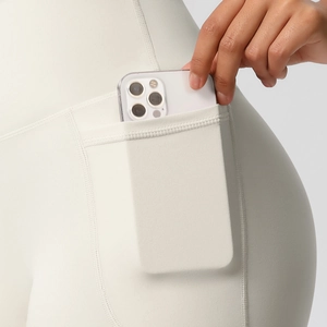 Detail of high-waist yoga shorts featuring a functional side pocket for a smartphone