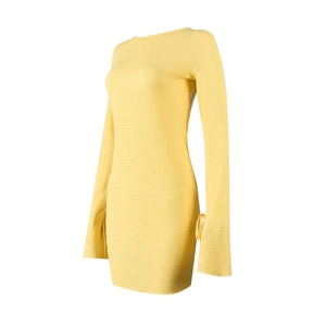 Détail de la robe moulante jaune montrant le tissu texturé et les manches à cordon