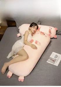 Close-up of pink pig plush body pillow being hugged on a cozy grey bed setting