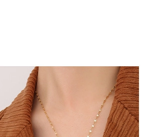 Close-up of minimalist gold thin chain necklace worn by a model in corduroy jacket