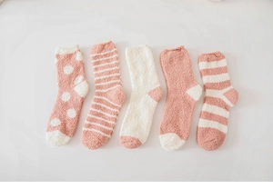 Flat lay of pink and white coral fleece socks set with striped and polka dot patterns