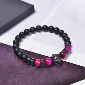 Detail of beaded men's bracelet with black matte stone and wolf head charm