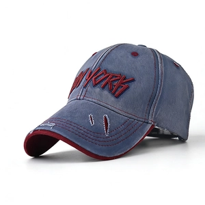 Detail of vintage denim baseball cap with distressed brim and red New York embroidery